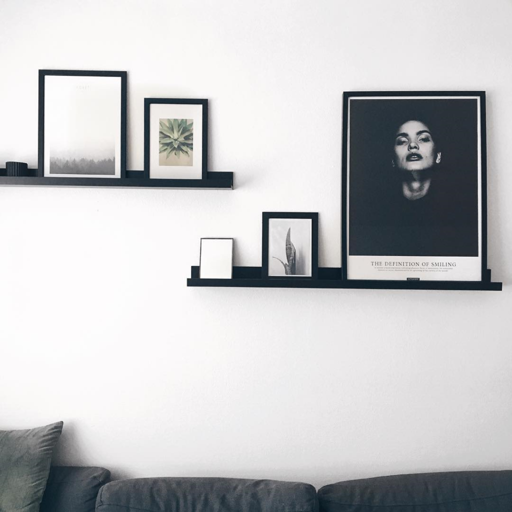 Sort hvid plakat på sort træ hylde over sofaen
