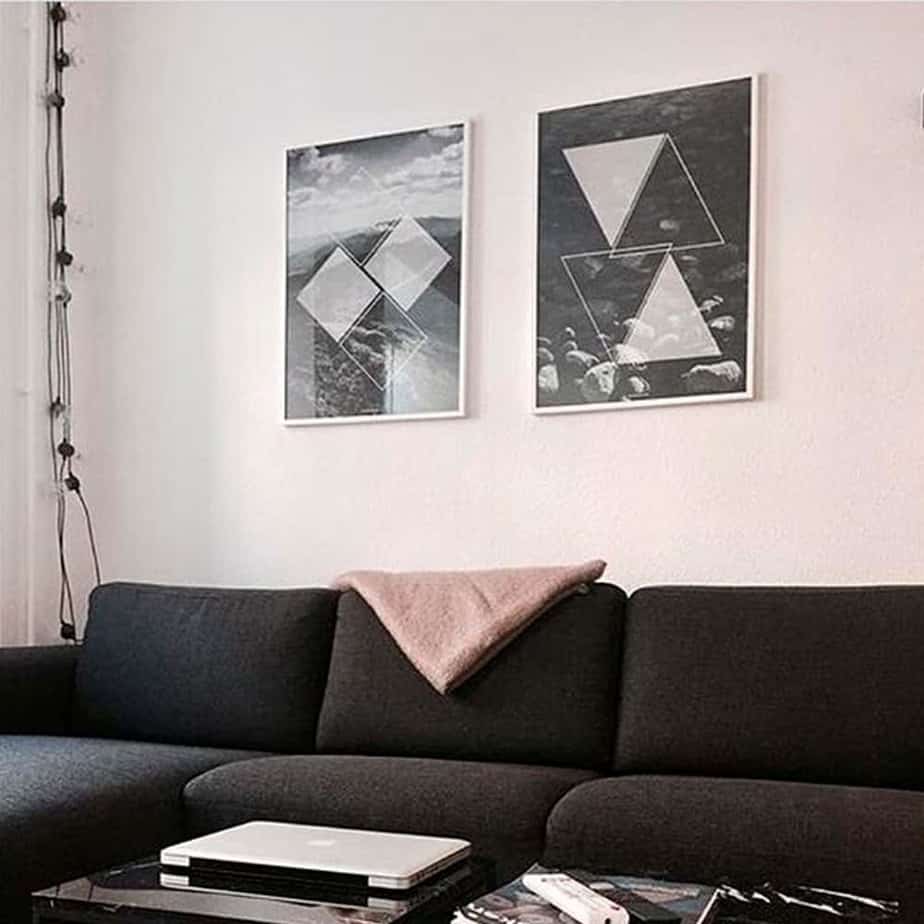 Sort hvid billeder hængende over sort sofa i hvid billederammer