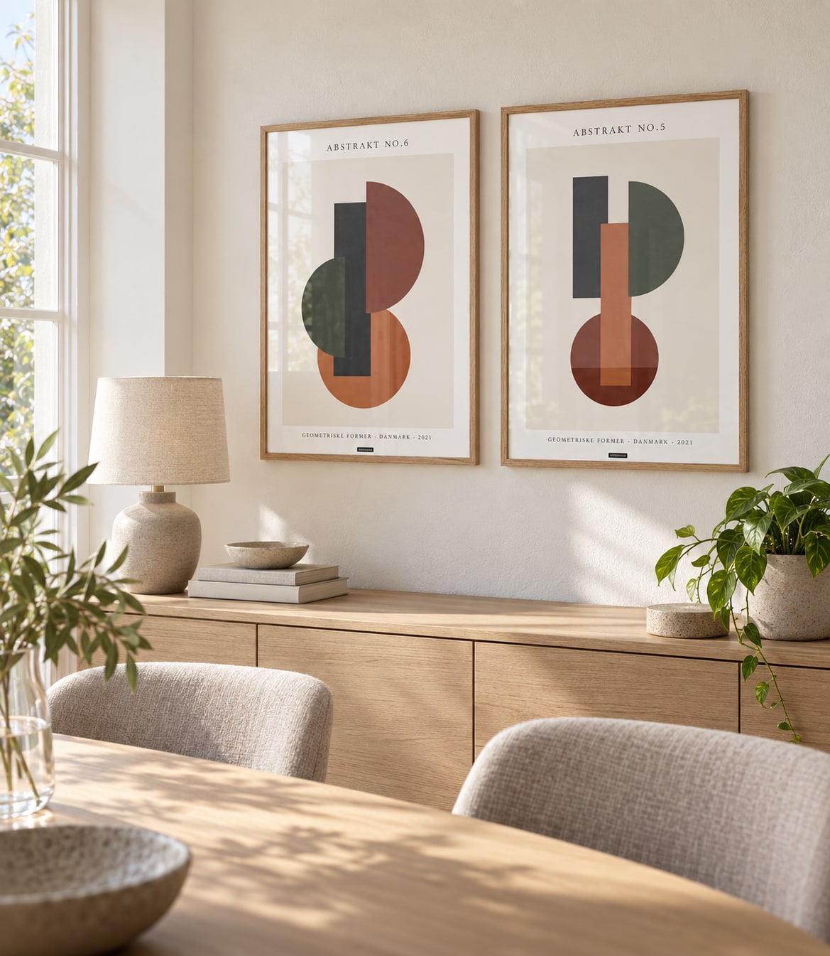 ABSTRAKT NO.5 og ABSTRAKT NO.6 plakater i egetræsræmmer i et lyst spisemiljø med naturligt dagslys