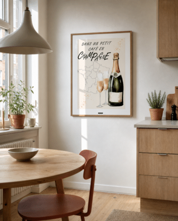 CHAMPAGNE NO.1 plakat i valnøddefarvet ramme i en lys dansk køkkenspisestue med egetræsskabe, terracotta stol, rundt bord og dagslys