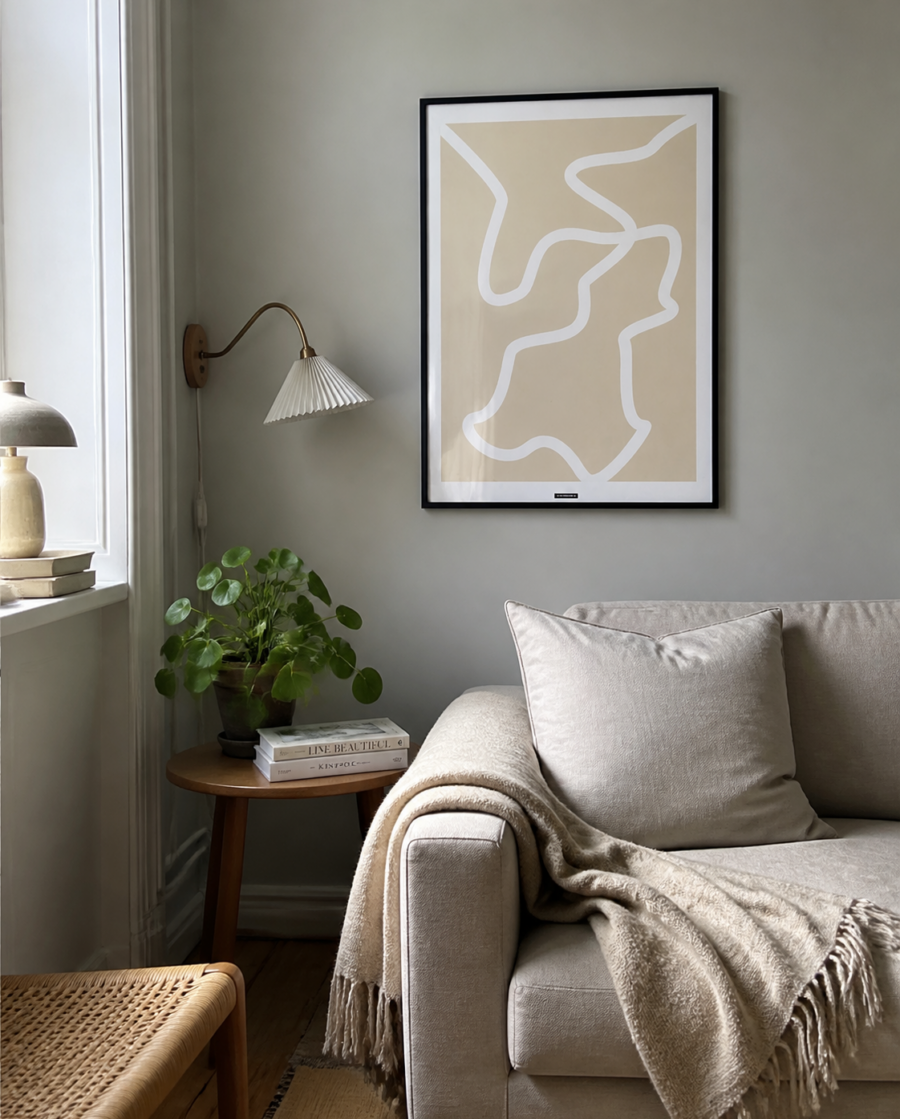 Lines No.1-plakaten med fine organiske linjer i sort ramme hænger på en rolig væg i en naturlig dansk stue med sofa, lampe og dagslys.
