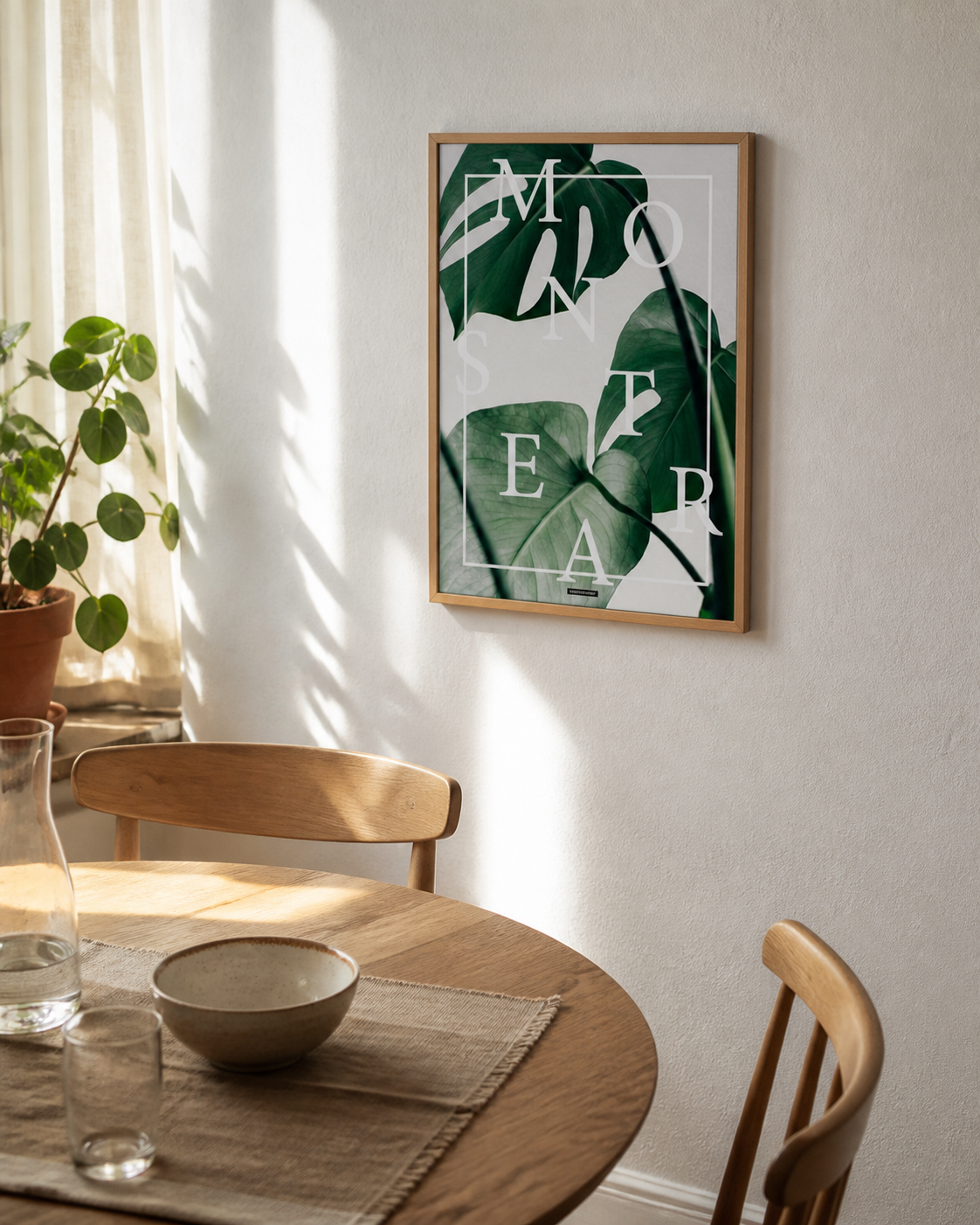 Monstera plakat i egetræsramme i en lys dansk spisestue