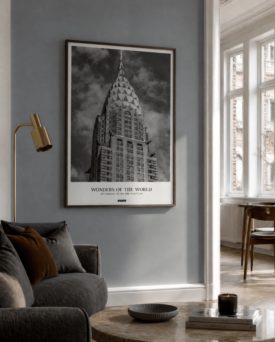 New York plakat i mørk træramme på en blå væg ved siden af et lyst vindue i en moderne stue
