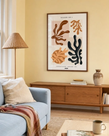 SEASON NO.1 plakat i valnøddefarvet ramme i en lys dansk stue med smørgul væg, lyseblå sofa, valnøddeskænk og flettet gulvlampe