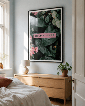 Wild Flower plakat i mørk ramme i lyst dansk soveværelse med blågrå væg, egetræskommode, hvidt sengetøj og naturligt dagslys